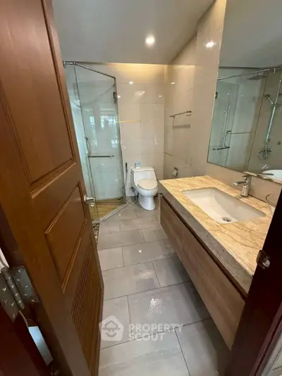 Modern bathroom with glass shower and elegant vanity in a stylish home.