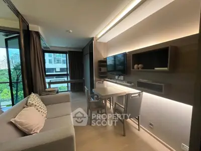 Modern living room with sleek furniture and large windows offering a lush green view.