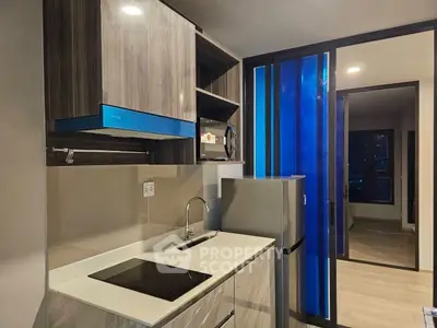 Modern kitchen with sleek appliances and stylish cabinetry in a contemporary apartment.