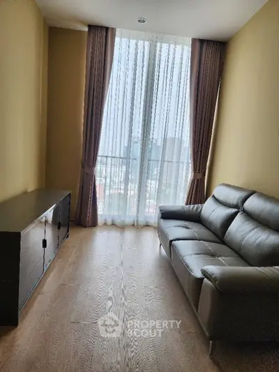 Modern living room with leather sofa and large window view