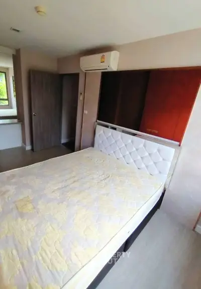 Spacious bedroom with modern air conditioning and stylish headboard in a cozy apartment.