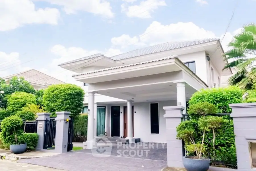 Elegant two-story house with modern design and lush greenery in a serene neighborhood.