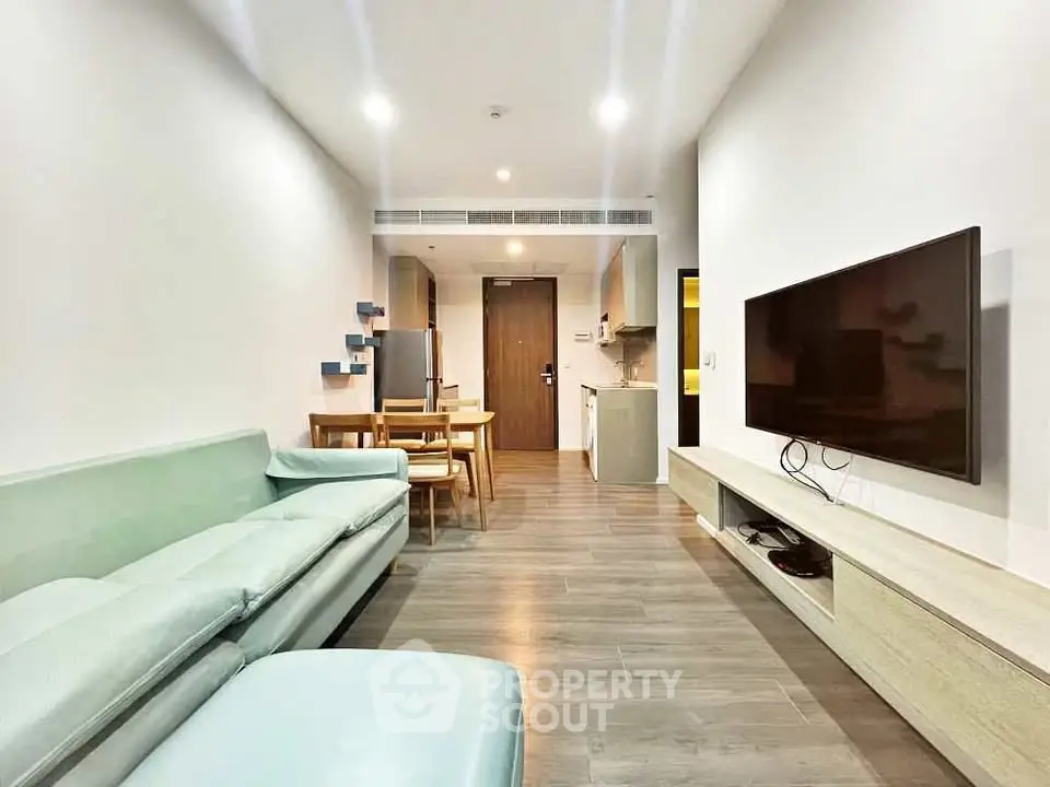 Modern living room with sleek furniture and open kitchen layout in a stylish apartment.