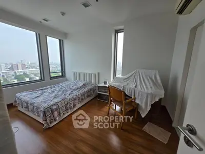 Spacious bedroom with city view and wooden flooring in modern apartment