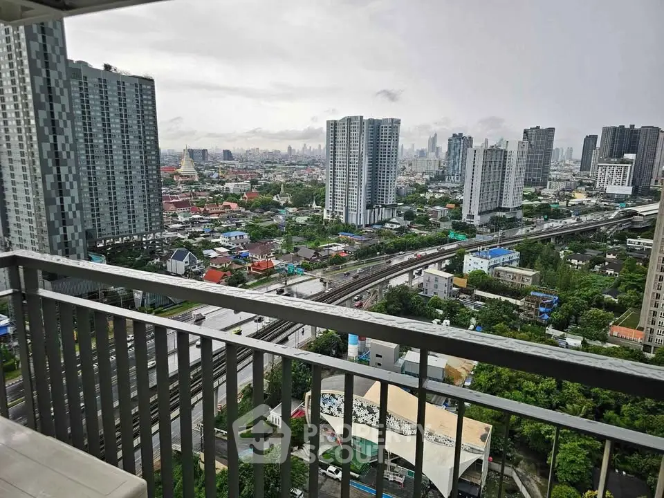 Stunning cityscape view from a high-rise balcony overlooking urban skyline and lush greenery.