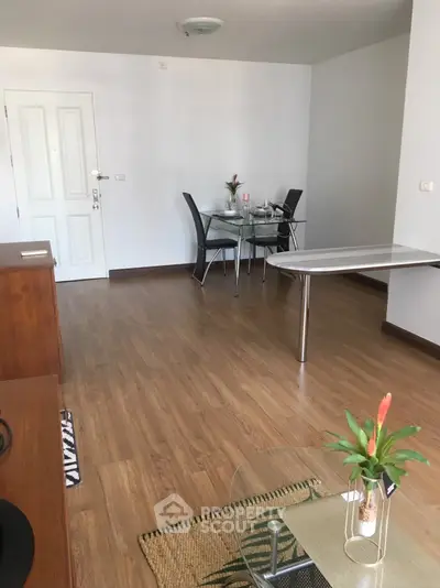 Spacious living room with modern dining area and elegant wooden flooring.