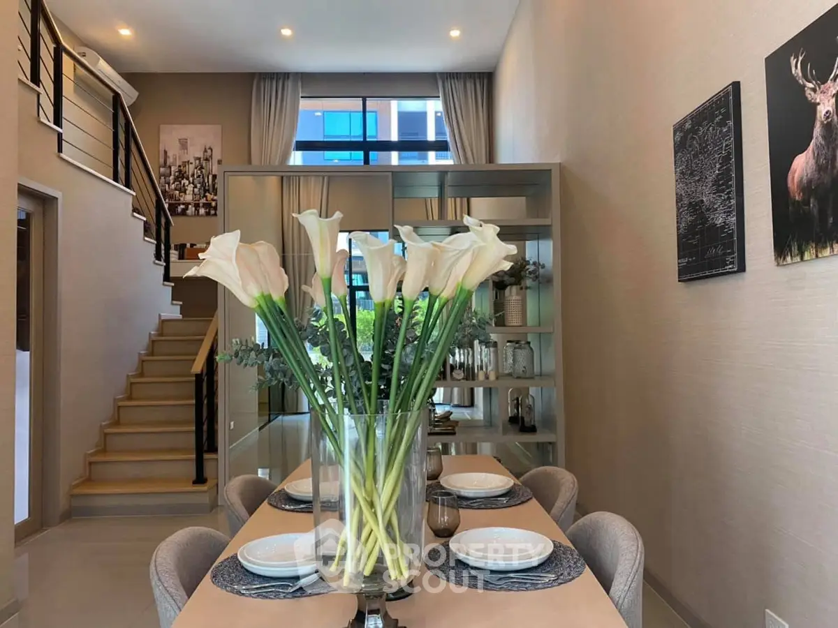 Elegant dining area with modern decor and staircase in stylish home