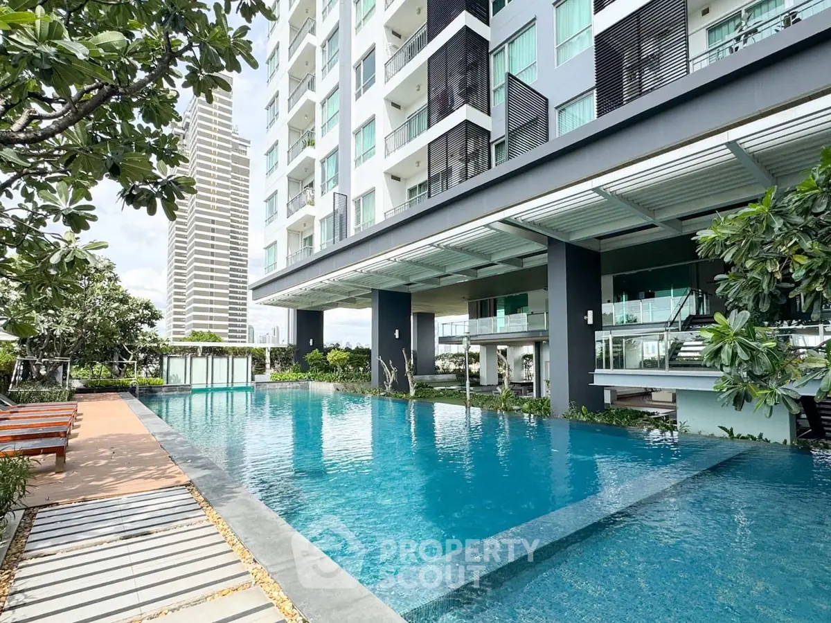 Luxurious condominium with stunning pool and modern architecture in urban setting.