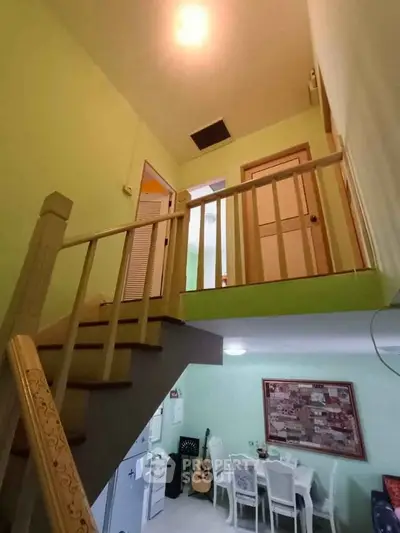 Charming two-story interior with dining area and staircase, perfect for cozy family gatherings.