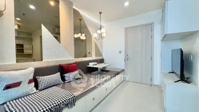 Modern living room with stylish decor and built-in seating, featuring elegant lighting and a sleek TV setup.