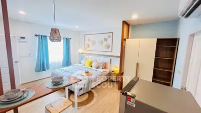 Charming bedroom with modern decor and natural light, featuring cozy bed and stylish furnishings.