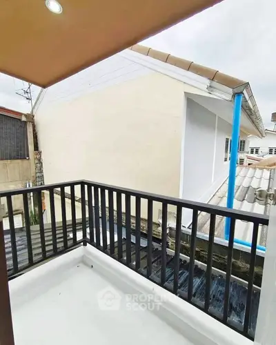 Charming small balcony with modern railing and urban rooftop view, perfect for relaxation.