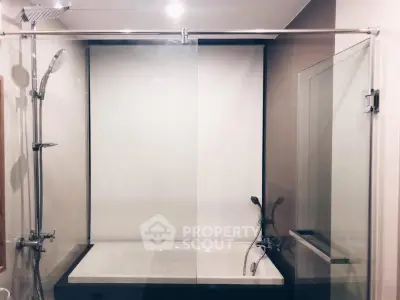 Modern bathroom with glass shower enclosure and bathtub in a stylish apartment.