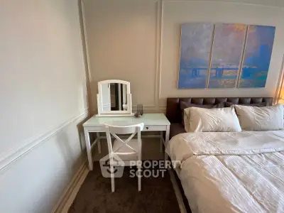 Elegant bedroom with stylish decor and cozy bedding, featuring a chic vanity desk and modern artwork.