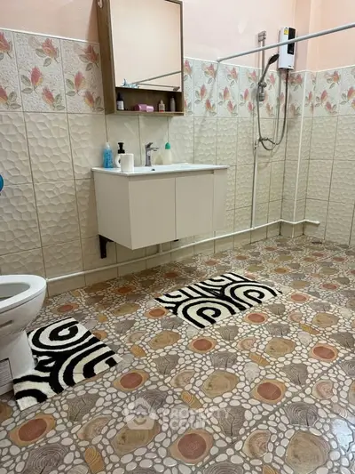 Spacious bathroom with unique tile design and modern fixtures