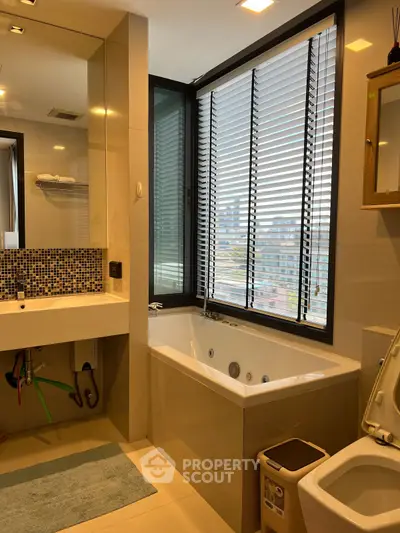 Modern bathroom with large window and bathtub, featuring sleek design and city view.