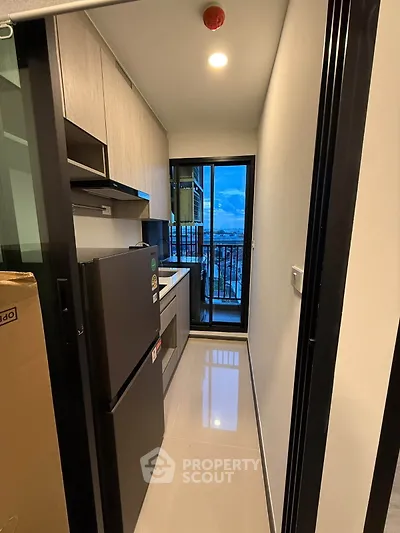 Modern compact kitchen with sleek appliances and balcony view
