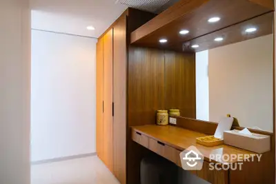 Elegant wooden wardrobe and vanity area with modern lighting in a stylish home interior.