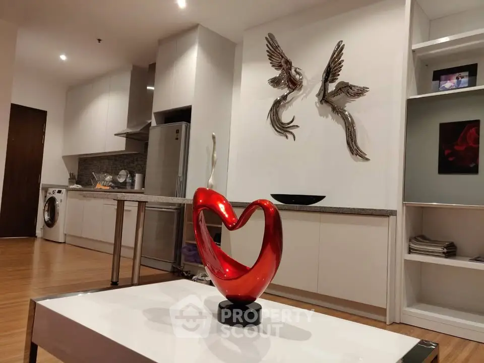 Modern open-layout kitchen with stylish decor and contemporary art in a cozy living space.