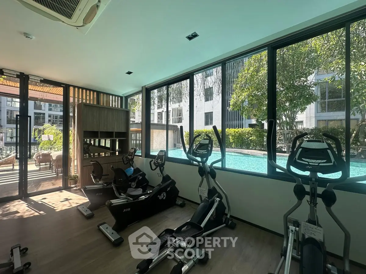 Modern gym with pool view in luxury residential complex
