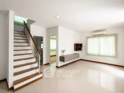 Spacious modern living room with staircase and natural light