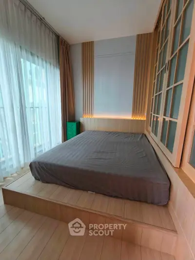 Modern bedroom with platform bed and floor-to-ceiling windows in stylish apartment.