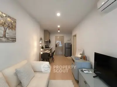 Modern living room with cozy sofa, dining area, and wall art in a stylish apartment.