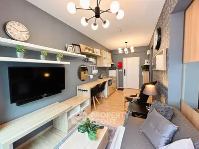 Modern living room with stylish decor, wall-mounted TV, and open kitchen layout in a cozy apartment.