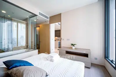 Modern bedroom with large windows and stylish decor in a luxury apartment.