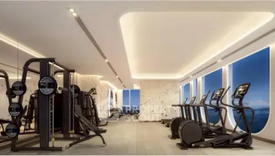 Luxurious gym with modern equipment and ocean view windows.