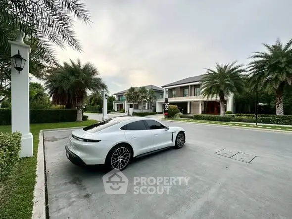 Luxurious modern home with sleek driveway and lush palm trees