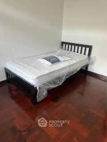 Spacious bedroom with new single bed and polished wooden floor