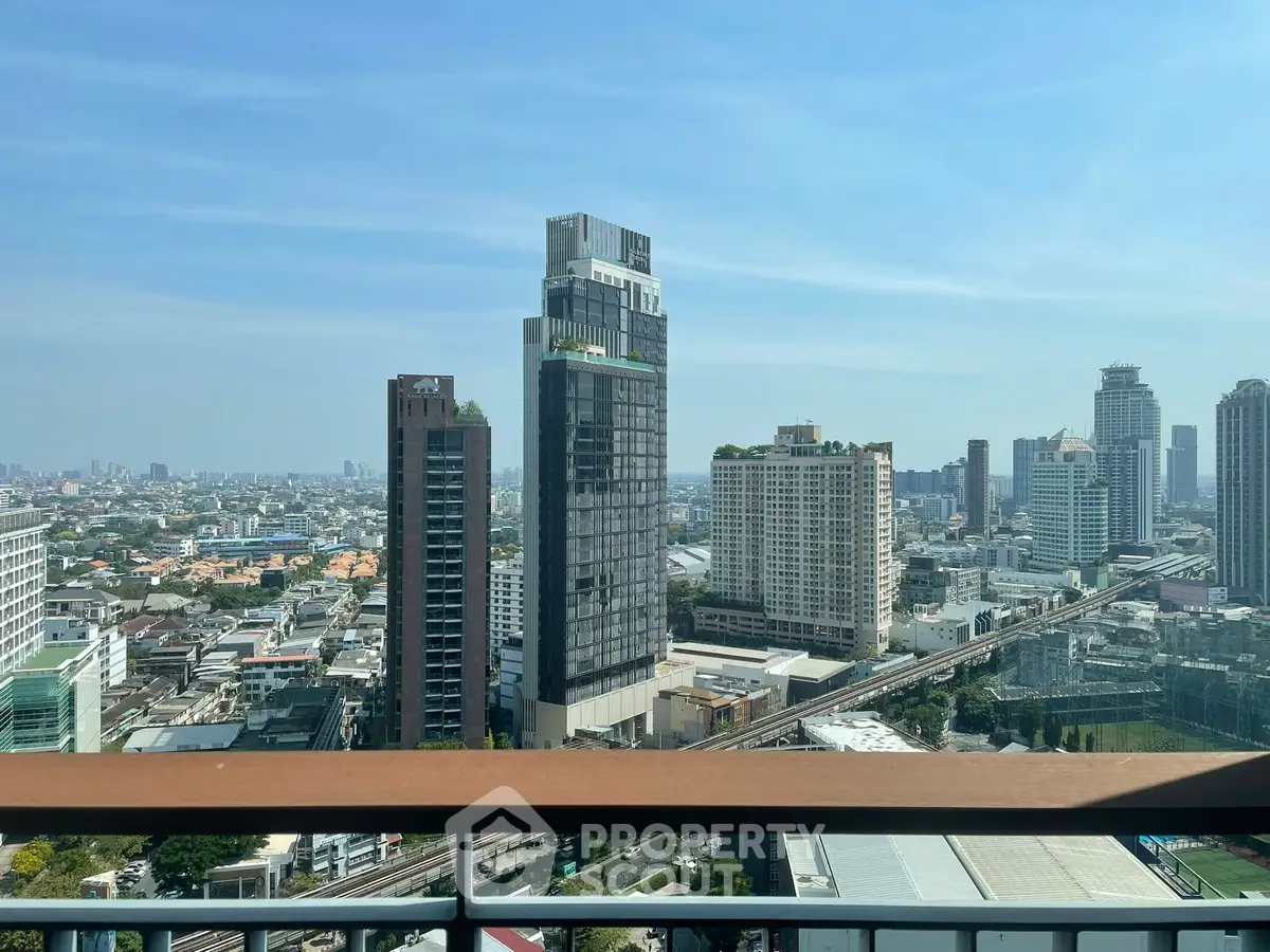 Stunning cityscape view from a high-rise balcony overlooking urban skyline and modern architecture.