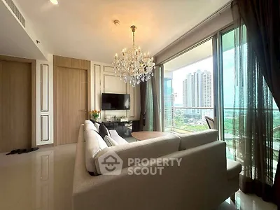 Luxurious living room with chandelier and stunning city view from large windows.