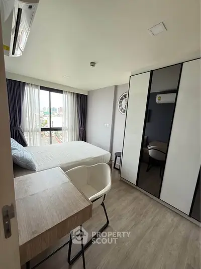 Modern bedroom with large window and stylish furniture in urban apartment