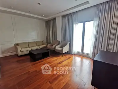 Spacious living room with elegant wooden flooring and modern furniture.