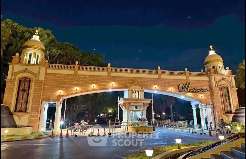 Elegant gated entrance of a luxury residential community at night, showcasing grand architecture and ambient lighting.