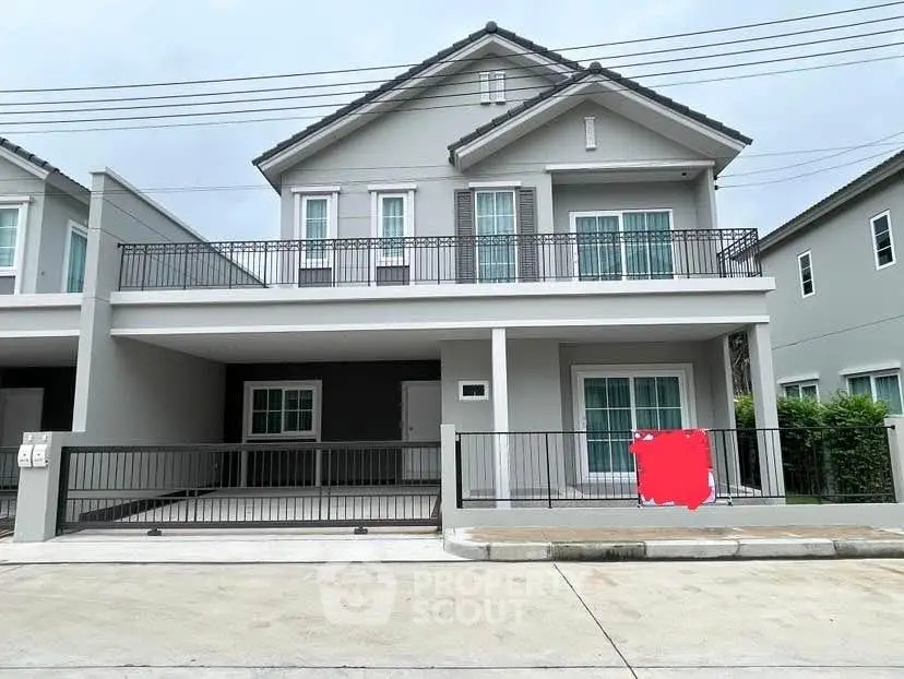 Modern two-story house with spacious balcony and driveway in suburban neighborhood.