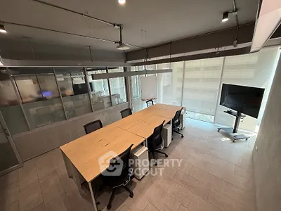 Modern office space with conference table and large windows offering natural light