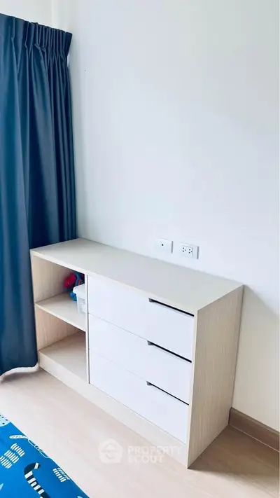 Modern bedroom with sleek white dresser and dark curtains, perfect for stylish living.