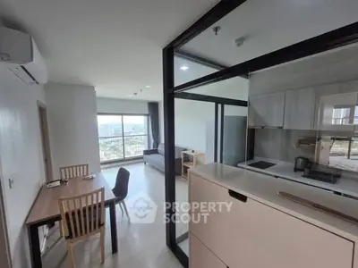 Modern open-plan living room with kitchen and city view balcony in a stylish apartment.