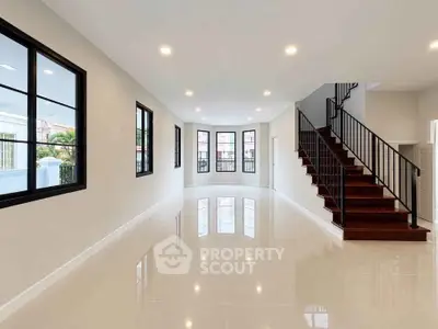Spacious modern living room with elegant staircase and large windows