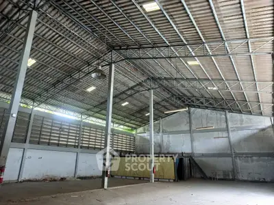 Spacious industrial warehouse with high ceilings and ample natural light, perfect for storage or manufacturing.