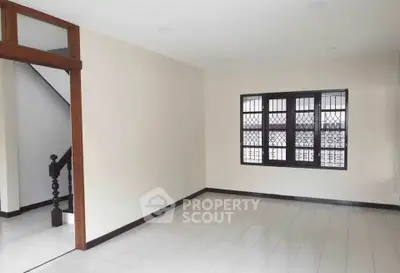Spacious living room with tiled floor and large window in modern home.