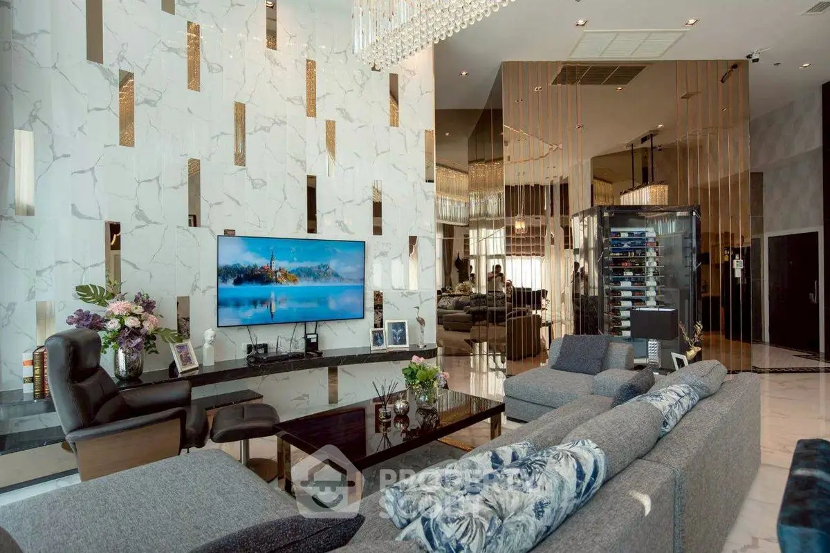 Luxurious modern living room with high ceilings, elegant decor, and a large TV, perfect for entertaining.