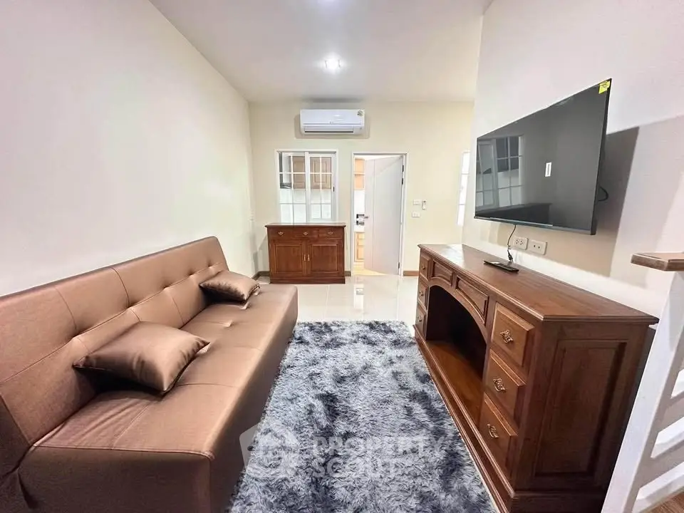 Cozy living room with modern sofa, TV, and air conditioning in a stylish apartment.