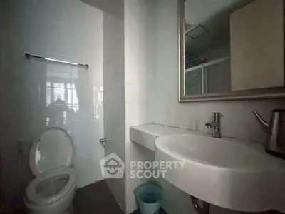 Modern bathroom with sleek fixtures and large mirror in a contemporary home.
