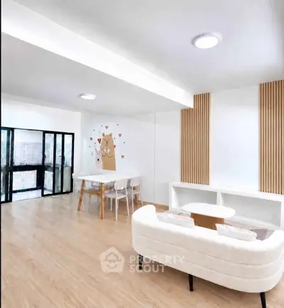 Modern living room with cozy seating and stylish decor, featuring a unique wall art and open layout.