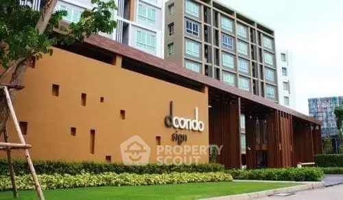 Modern condominium building with stylish facade and lush greenery.