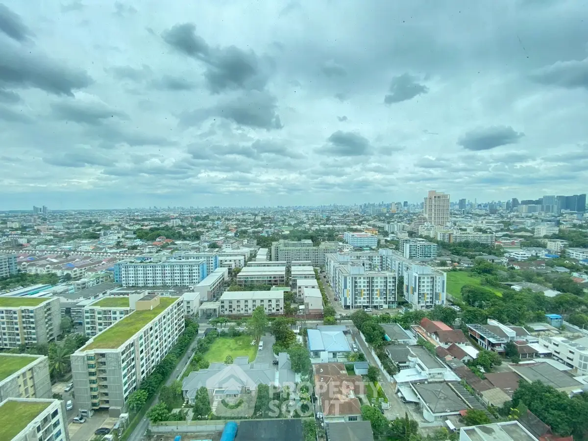 Stunning cityscape view from high-rise apartment, showcasing urban skyline and lush greenery.